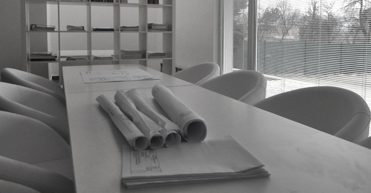Kancelária DESIGN HOUSE so zasadacím stolom a architektonickými výkresmi